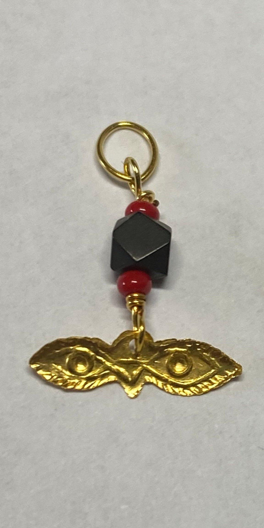 Charm de ojos pequeños "Santa Lucía" de oro amarillo de 10 quilates con azabache auténtico y coral